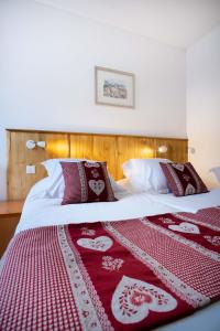 a bedroom with two beds with red and white blankets at Hotel Relais d'ISSENHEIM Table d'hôtes in Issenheim