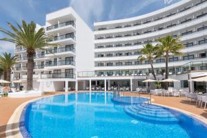 a hotel with a large swimming pool in front of a building at HSM Linda Playa in Paguera