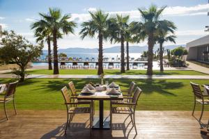 a table and chairs on a patio with palm trees at ON'LIVE HOTEL in Çeşme