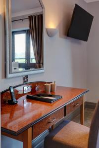 a desk with a chair and a lamp on top of it at The Hillcrest Hotel in Widnes