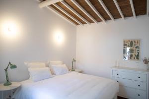 um quarto branco com uma cama branca e uma cómoda em Casa da Travessa em Évora