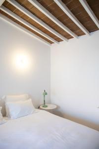 a bedroom with a white bed and a table at Casa da Travessa in Évora