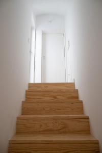 a set of wooden stairs in a room with a door at Casa da Travessa in Évora