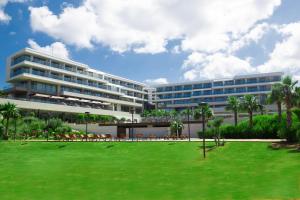 a large building with a green lawn in front of it at ON'LIVE HOTEL in Cesme