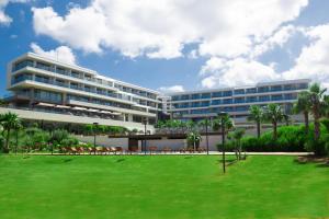 a large building with a green lawn in front of it at ON'LIVE HOTEL in Çeşme