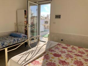 een slaapkamer met 2 bedden en een raam met uitzicht bij Relais Regina Giulia in Gallipoli