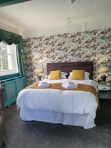 1 dormitorio con 1 cama grande y pared de flores en Marley House Bed and Breakfast, en Winfrith Newburgh