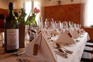 einen Tisch mit einer Flasche Wein und Weingläsern in der Unterkunft Gasthof zur Brücke in Kaufering