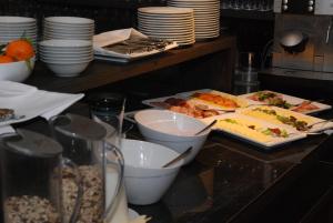 a buffet with plates and food on a table at Arte Luise Kunsthotel in Berlin