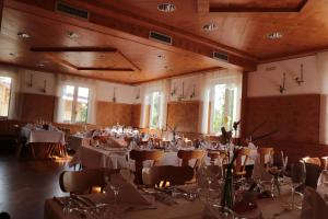 um salão de banquetes com mesas e cadeiras brancas em Gasthof zur Brücke em Kaufering