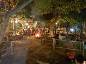 un grupo de personas sentadas alrededor de un fuego por la noche en Sagando Bungalows Zanzibar, en Michamvi