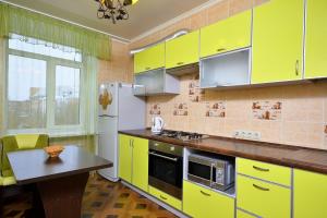オムスクにあるApartment Karla Marksa 22の黄色のキャビネットとテーブル付きのキッチン