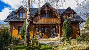 a log home with a porch and a deck at Roztoczański Dworek in Zamość