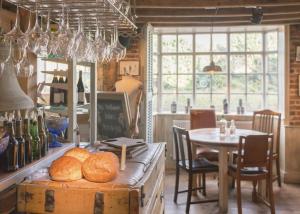 Brabourne的住宿－The Five Bells Inn，厨房配有桌子和带面包的桌子