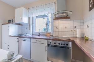 a kitchen with white appliances and a window at Nordic Hus Büsum in Büsum