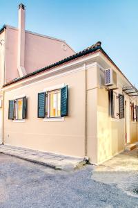 Una casa amarilla con persianas negras. en CASA MIRKA Corfu Petite Maisonette, en Anemómylos