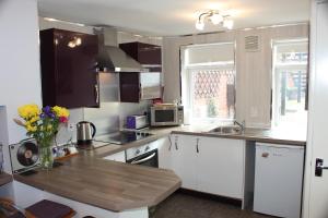 uma cozinha com armários brancos e um balcão de madeira em Cadame em Whitby