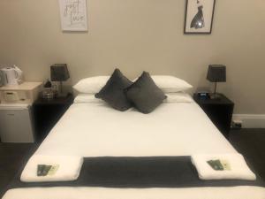 a bedroom with a large white bed with black pillows at Wentworth Hotel in Sydney