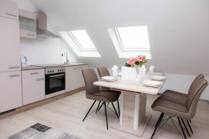 デュースブルクにあるT&K Apartments near Messe Fair Trade Düsseldorf und Airport 3Bのキッチン(テーブル、椅子、花付) +5枚の写真