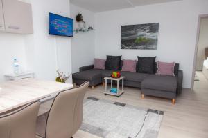 ein Wohnzimmer mit einem Sofa und einem Tisch in der Unterkunft T&K Apartments near Messe Fair Trade Düsseldorf und Airport 3B in Duisburg