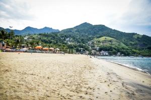 - une plage avec un groupe de personnes et l'océan dans l'établissement Cantinho da Vitória em Conceição de Jacareí, à Mangaratiba