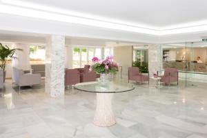 a lobby with a glass table with flowers on it at HSM Solivera in Paguera +32 photos