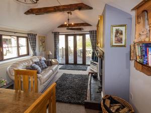 a living room with a couch and a tv at Cwm Derw Cottage in Llanafan-fawr