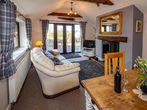 uma sala de estar com um sofá e uma mesa em Cwm Derw Cottage em Llanafan-fawr
