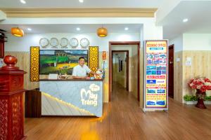 a restaurant with a counter with a man behind it at Homestay May Trang in Hoi An