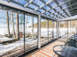 a screened porch with a table and chairs and a view of the water at Holiday Home Hukka 6 by Interhome in Harkala