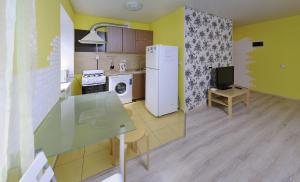 オムスクにあるOmsk Sutki Apartments on Karla Marksa 31のキッチン(冷蔵庫、テーブル、テレビ付)