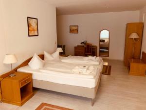 um quarto com 2 camas e lençóis brancos em Hotel Zum Strand em Warnemünde