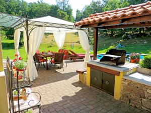 Un patio con parrilla y mesa y sillas. en Holiday Home Škalniški by Interhome, en Mučići