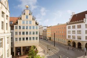 a large building with a clock on the side of it at Vienna House Sonne Rostock in Rostock