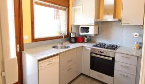 a small kitchen with a sink and a stove at Pool and relax 20' from Barcelona in Premiá de Mar
