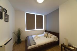 - une petite chambre avec un lit et une fenêtre dans l'établissement Bright Central London Apartments by DC London Rooms, à Londres