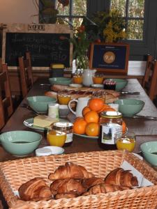 uma mesa com pão e laranjas sobre uma mesa em Domaine de Laverchère em Pommiers-en-Forez