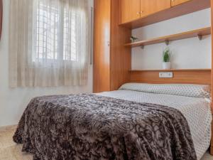 1 dormitorio con 1 cama con manta marrón en Holiday Home Gavina by Interhome, en Torredembarra