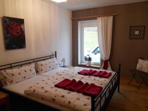 ein Schlafzimmer mit einem Bett mit roten Kissen darauf in der Unterkunft Apartment Carpe Diem in Kramsach