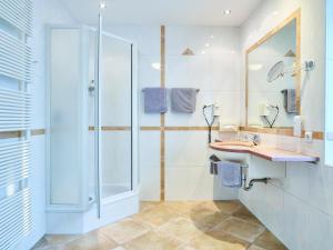 a bathroom with a shower, sink, and tub at Das Grüne Hotel zur Post - 100 % BIO in Salzburg