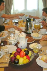 una mesa con un montón de comida y fruta en ella en Chambres d'Hôtes Le Tilleul, en Saint-Hilaire-des-Loges