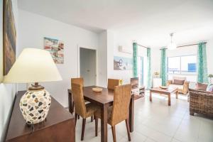 comedor y sala de estar con mesa y sillas en Apartamento Almadraba, en Chiclana de la Frontera