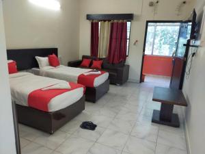 a hotel room with two beds and a couch at HOTEL BUDDHA in Kushinagar