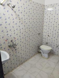 y baño con aseo y lavamanos. en HOTEL BUDDHA, en Kushinagar