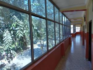 a hallway with large windows in a building at HOTEL BUDDHA in Kushinagar
