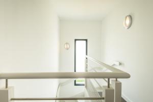 een trap in een wit gebouw met een metalen leuning bij Les Cottages d'ANADARA in Anglet