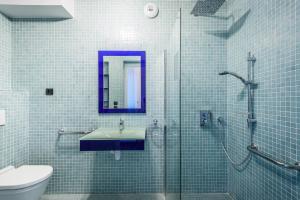 een badkamer met een wastafel en een glazen douche bij Les Cottages d'ANADARA in Anglet