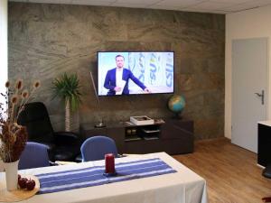 a living room with a tv on a stone wall at Ferienwohnung Bernhardt in Zella-Mehlis