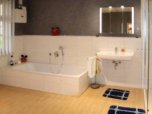 a bathroom with a bath tub and a sink at Ferienwohnung Bernhardt in Zella-Mehlis +9 photos