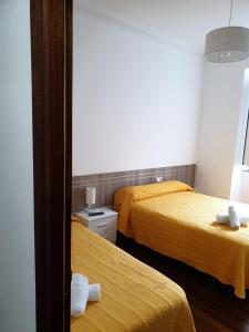 a hotel room with two beds and a mirror at Pensión Hedrass in Santiago de Compostela